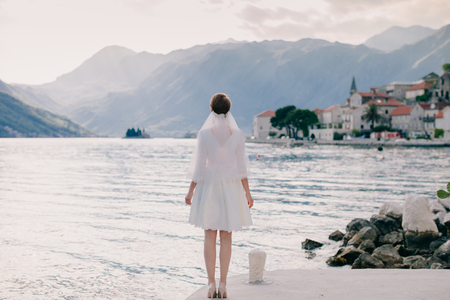 unidentified bride walking in picturesque bay with mountains view. Luxury bride in Montenegro, Perast.の写真素材