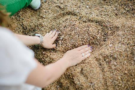 Woman drawing a heart in the sand. Close upの写真素材