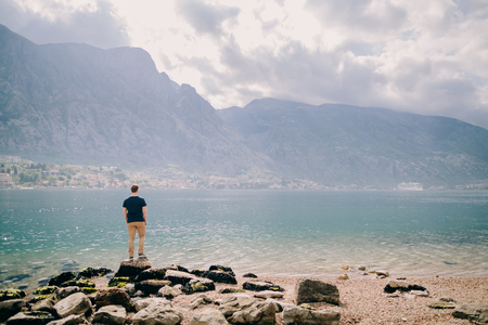 man travel rocky beach and mountains bay view. Kotor Bay, Montenegroの写真素材
