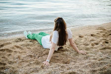 woman in green pants on beach. Relaxing on beach. back view. Montenegroの写真素材