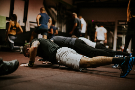 Cross fitness group training workout indoors. Group fitness workout with weightsの写真素材