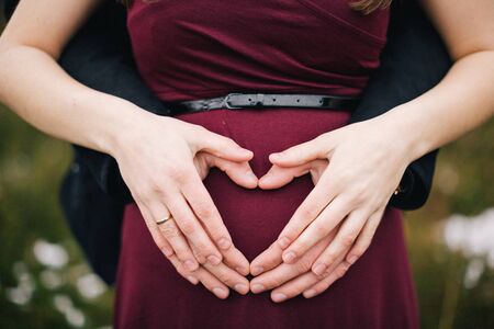 pregnant belly and heart shape from the handsの写真素材