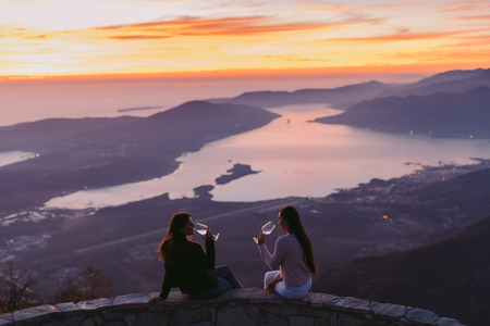 women drink wine together at sunset in mountains. Beautiful view,. Montenegro, Kotorの写真素材