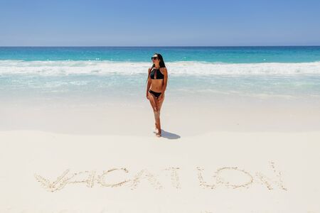 woman on beach vacation in tropics. Beach vacation. Hot beautiful woman in bikini on beach in tropics. Seychelles.の写真素材