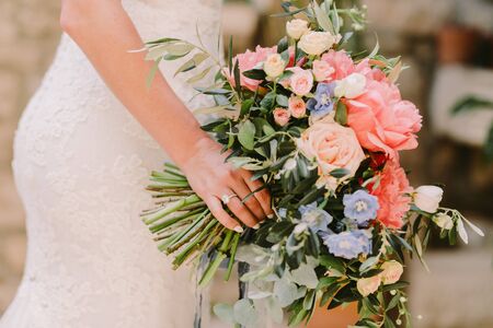 bride holding wedding bouquet in fine art style. Fine art wedding bouquet with peonies. Airy photoの写真素材