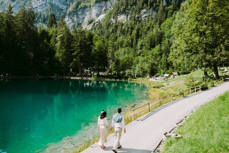 couple travel to mountain lake and forest. Honeymoon couple walk in the forest lake in Switzerland....
