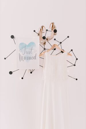 just married sign with wedding dress and shoes on white wall background. Wedding background decoration.の写真素材