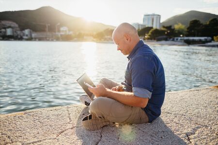 freelancer browsing laptop on beach using wifi network. Self employed man travel and consulting through internet. Holiday maker travel and using internet connection on beach.の写真素材
