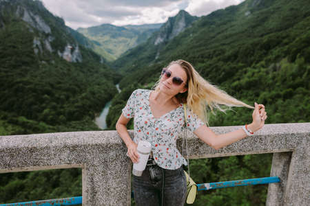attractive woman relax in mountains and holding coffee mugの写真素材