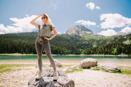 attractive woman relax in mountains with lake view and forestの写真素材