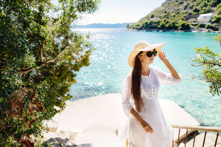 girl in summer dress and hat travel to sea sideの写真素材