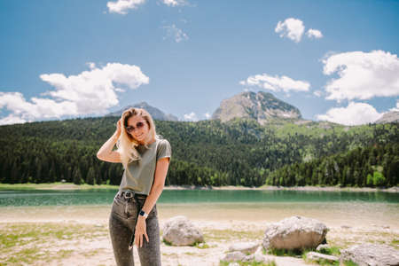 attractive woman relax in mountains with lake view and forestの写真素材