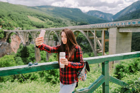 woman travel and taking photos on smartphone at countrysideの写真素材