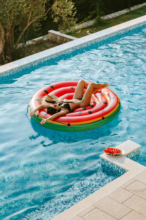 sexy woman relax in swimming pool on inflatable fun beach floaty outdoors