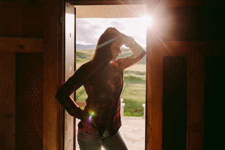 portrait of woman in door of house with sunlightの写真素材