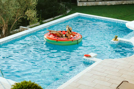 woman relax in swimming pool on inflatable pool toyの写真素材