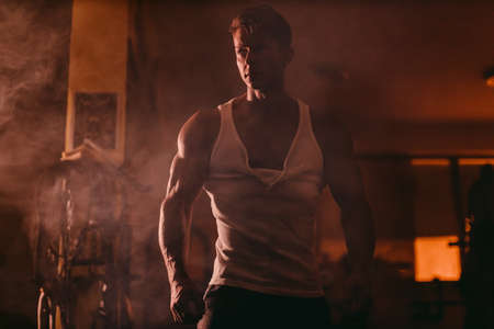 Powerful Muscular man posing in darkness