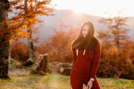 Portrait of woman in autumn forest at sunsetの写真素材