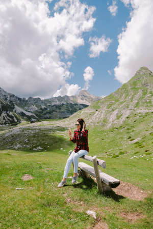 pretty woman traveller using smartphone in mountainsの写真素材