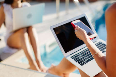 woman working with friend on laptop and chatting online