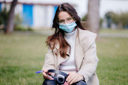young woman student virtual learning on mobile wearing medical mask new normalの写真素材