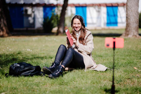 young woman online learning on mobile internet outdoorsの写真素材