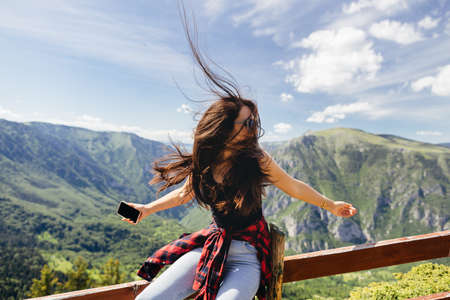 beautiful woman relax in mountains with smartphoneの写真素材