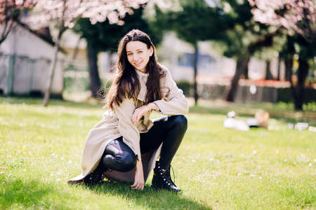 lifestyle fashion portrait of young happy woman outdoorsの写真素材