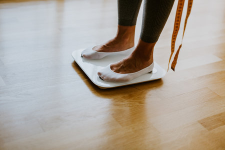 Woman Measuring Body Weight On Weighing Scale At Home.の写真素材