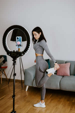 Attractive Woman online fitness workout at home. fitness influencerの写真素材