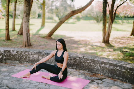 young woman meditation yoga practice morning routine outdoors in park