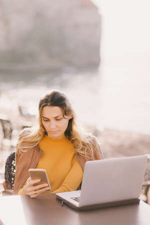 serious young business woman work on laptop and smartphone outdoorsの写真素材