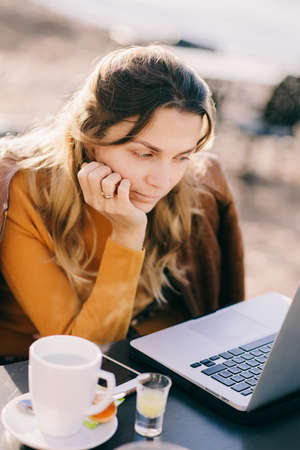 concentrated Female entrepreneur work on laptop outdoors in cafeの写真素材