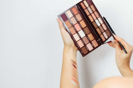 woman choosing eyeshadow palette for make upの写真素材