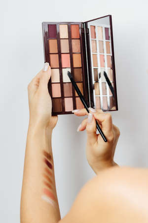 woman choosing eyeshadow palette for make upの写真素材