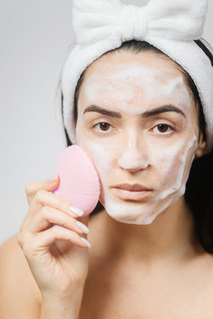 beautiful woman using cleansing brush for face deep cleaning