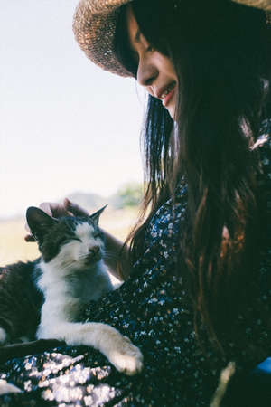 A woman stroking a cat on the beach