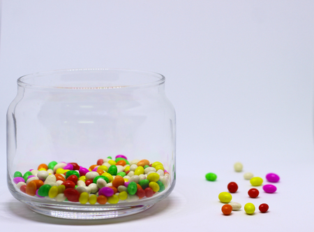 Multiple colored Sugar Candy In Glass Container in White Backgroundの写真素材