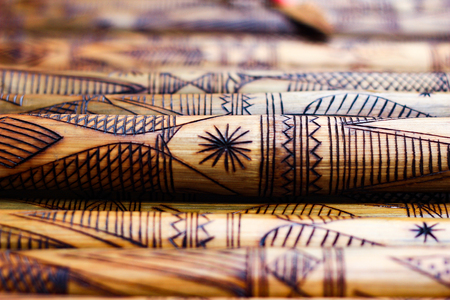 hand made wooden bamboo carving engraved fish figure artwork on bamboo, rows of engraved bamboo sticks. textured background. tribal artwork.の写真素材