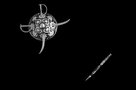 decorated round sword and shield and pen isolated in black background with copy space for text....