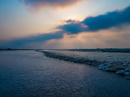 Blue hour at the sea. Waves approaching the shore during sunrise