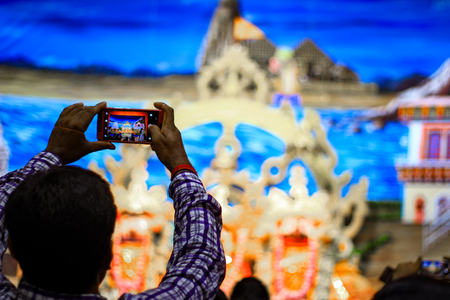 Durgapur, West Bengal, India. July, 2018 A Devotee clicking photo of idols of Jagannath Balaram Suvadra at Rath Yatra Festival during Night. Rath Yatra is a very famous Hindu festival worldwide.のeditorial素材