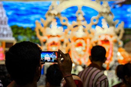Durgapur, West Bengal, India. July, 2018 A Devotee clicking photo of idols of Jagannath Balaram Suvadra at Rath Yatra Festival during Night. Rath Yatra is a very famous Hindu festival worldwide.のeditorial素材
