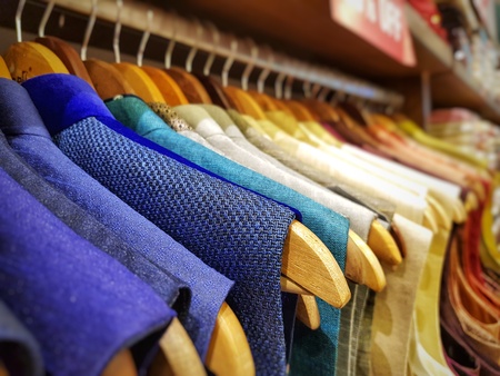 multi color dress sherwani kurta hanging from hangar in a garment shop for saleの写真素材