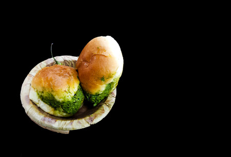 Vada pau bread and green sauce on a plate in dark backgroundの写真素材