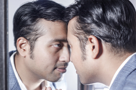 asian man in suit looking after his appearance in front of a mirror beauty styling lifestyle.の写真素材