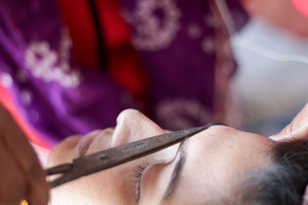 shaping and plucking of eye brow with scissors. cosmetic procedure in beauty parlour.の写真素材