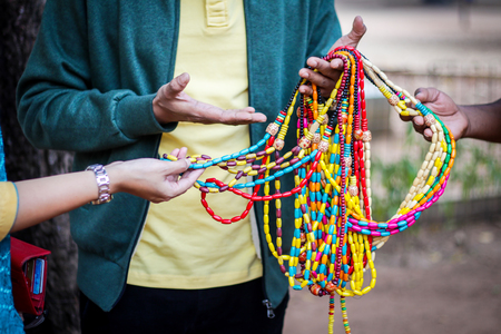 a vendor selling various colourful beaded necklace junk jewelryの写真素材