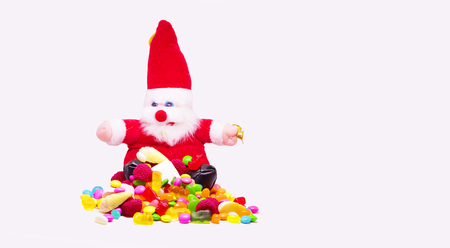 santa clause and multi coloredcandy in white background with space for textの写真素材