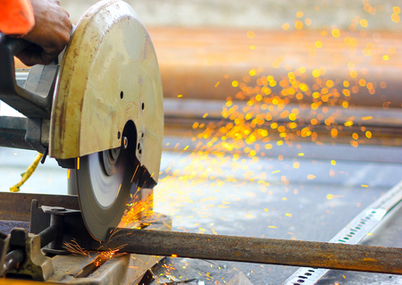 cutting of iron steel TMT bars with motorised steel cutter and generation of sparksの写真素材